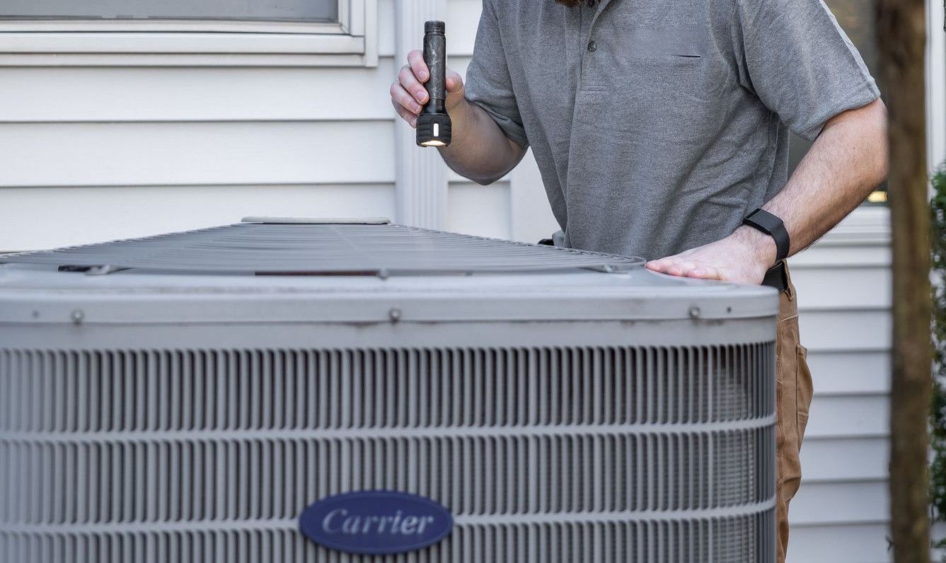 A technician inspects an outdoor HVAC unit for maintenance.